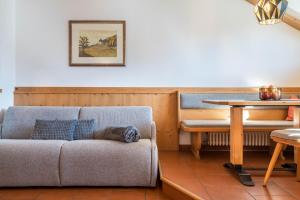 een woonkamer met een bank en een tafel bij Häuslerhof App Larix in Villabassa