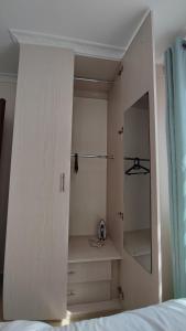 a bedroom with a white cabinet and a mirror at Bliss Escapes in Ruiru