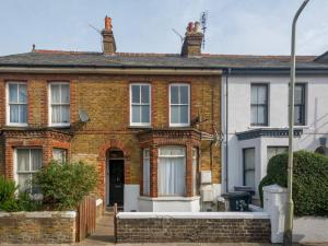 a red brick house with a white at Pass the Keys Spacious and Modern Sea Side apartment in Whitstable