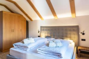 1 dormitorio con 1 cama con toallas en Häuslerhof App Tilia, en Villabassa