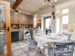 a kitchen with a white table and chairs and a table and chairsktop at Oak Cottage in Skipton