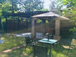 patio con ombrellone, tavolo e sedie di Casa estilo cabaña "Rosita" a Paso de la Patria