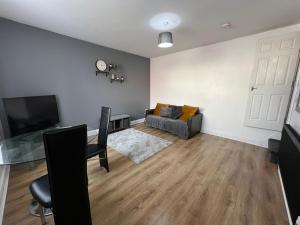 a living room with a couch and a television at Leeds Serviced Accommodation in Killingbeck