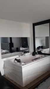 a large white tub in a room with a mirror at Venecia Hotel Larco in Trujillo