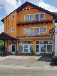 een groot oranje gebouw met ramen en een balkon bij Pensiunea Baron in Sighişoara