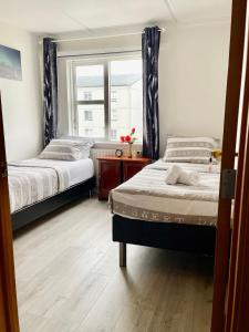 1 dormitorio con 2 camas y ventana en G-1215 apartment en Ytri-Njarðvík