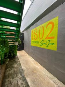 a yellow sign on the side of a building with plants at 1802 at San Juan in San Juan