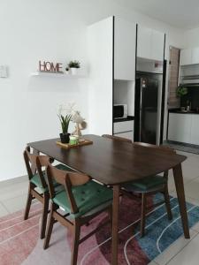 a wooden table and chairs in a kitchen at RatuSpaQ Home Desaru Utama Residence Apartment in Bandar Penawar