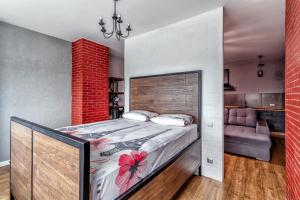 1 dormitorio con 1 cama grande y una pared de ladrillo rojo en Apartment Severnoye Siyaniye 37, en Astana