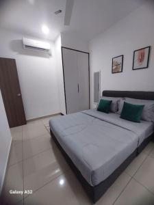 a bedroom with a large bed with green pillows at RatuSpaQ Home Desaru Utama Residence Apartment in Bandar Penawar