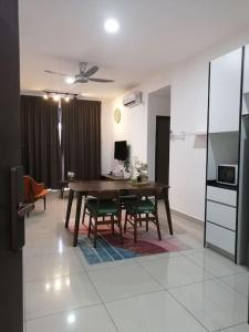 a living room with a wooden table and chairs at RatuSpaQ Home Desaru Utama Residence Apartment in Bandar Penawar