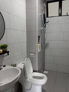 a white bathroom with a toilet and a sink at RatuSpaQ Home Desaru Utama Residence Apartment in Bandar Penawar