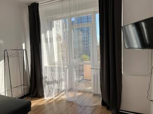 a living room with a large window with black curtains at Best 1 Room Condo in Warszawa Center in Warsaw