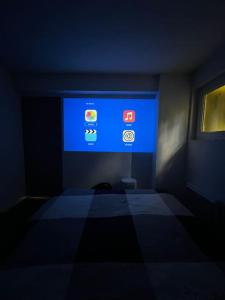 a dark room with a room with a blue screen at Appartement T2 Bayonne-Anglet in Bayonne