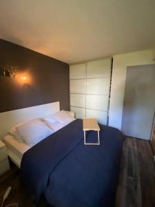 a bedroom with a blue bed with a table on it at Appartement T2 Bayonne-Anglet in Bayonne