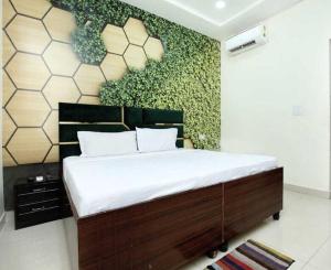 een slaapkamer met een groot bed met een groene muur bij OYO Hotel Golden Crown in Rājpura