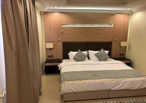 1 dormitorio con 1 cama grande y cabecero de madera en فندق الفرسان en Yeda