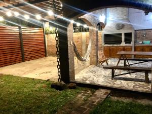 patio con tavolo da picnic e camino in pietra di Casa estilo cabaña "Rosita" a Paso de la Patria