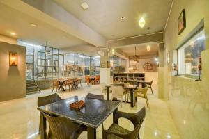 a dining room with tables and chairs in a building at Royal Casa - Asra Hotel in Chandrāvati