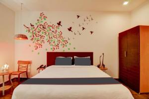 a bedroom with a bed with birds on the wall at Royal Casa - Asra Hotel in Chandrāvati