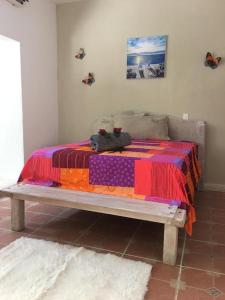 Una cama con una manta de colores encima. en Cabrera Chalet boutique hotel en Cabrera