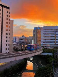 a train on a bridge in a city at Guest House Umikaji in Naha