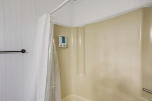 eine Dusche mit einem weißen Duschvorhang im Bad in der Unterkunft North Carolina Abode - Deck and Grill, Walk to Beach in Oak Island + 18 Fotos