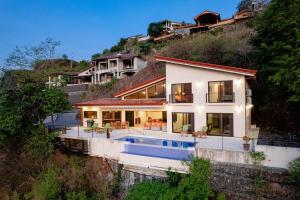 a house on a hill with a swimming pool at Casa de la Paz in Playa Hermosa