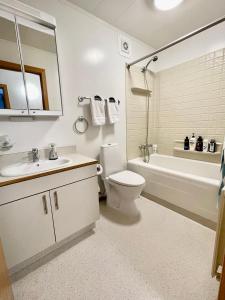 a bathroom with a sink and a toilet and a bath tub at G-1215 apartment in Ytri-Njarðvík
