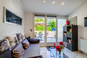 a living room with a couch and a glass table at Appartement Lou Paradou in Saint-Cézaire-sur-Siagne