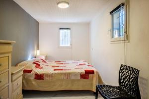 a bedroom with a bed and a chair in it at Appartement Lou Paradou in Saint-Cézaire-sur-Siagne +17 photos