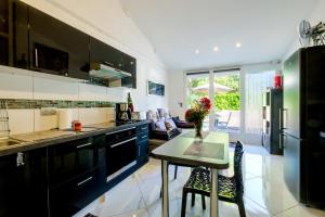 a kitchen with black cabinets and a table with flowers on it at Appartement Lou Paradou in Saint-Cézaire-sur-Siagne