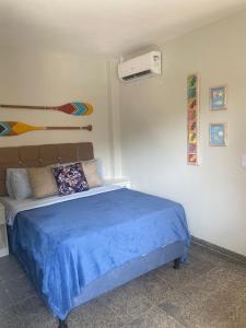 ein Schlafzimmer mit einem Bett mit einer blauen Decke in der Unterkunft Segunda Casa- Seu cantinho na Praia do Morro em Guarapari - Quartos suítes 2 até 4 pessoas in Guarapari