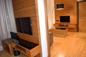 a living room with wooden walls and a flat screen tv at Royal Suites At Dua Sentral in Kuala Lumpur