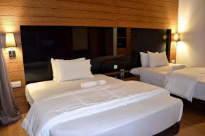 a hotel room with two beds with white sheets at Royal Suites At Dua Sentral in Kuala Lumpur