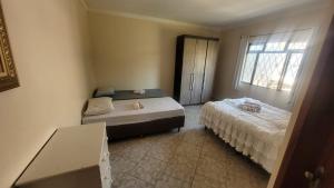 a bedroom with two beds and a window at Casa Feliz in Cascavel