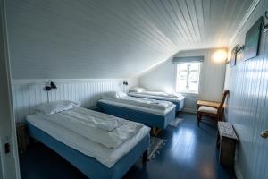 een kamer met 2 bedden en een raam bij Lofoten Island Lodge in Henningsvær