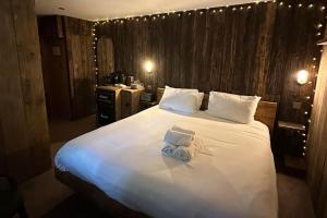 ein Schlafzimmer mit einem großen weißen Bett und einem Handtuch darauf in der Unterkunft Quirky Retreats - The Hidden Retreat in Windermere + 9 Fotos