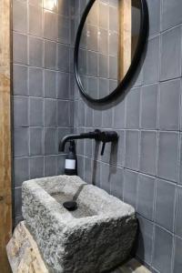 ein Badezimmer mit einem Steinwaschbecken und einem Spiegel in der Unterkunft Quirky Retreats - The Hidden Retreat in Windermere