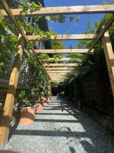 Eine hölzerne Pergola mit Topfpflanzen auf einem Weg in der Unterkunft Quirky Retreats - The Hidden Retreat in Windermere