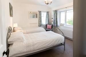 1 dormitorio con 2 camas y ventana en Bryn Gwyn, Sleeps 8, Sea Views, Borth y Gest, en Porthmadog