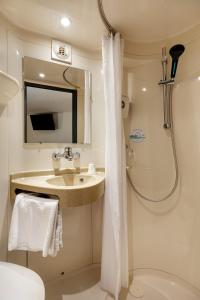 a bathroom with a sink and a shower at Premiere Classe Bethune Fouquières Lès Béthunes in Fouquières-lès-Béthune