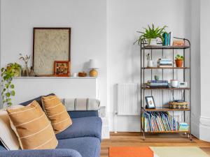 a living room with a blue couch and a shelf at Pass the Keys Spacious Sea Side apartment in Folkestone