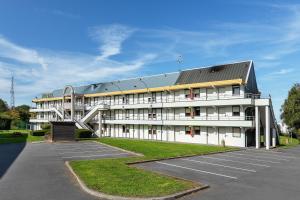 a large white building with a parking lot at Premiere Classe Bethune Fouquières Lès Béthunes in Fouquières-lès-Béthune
