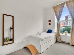 a bedroom with a bed and a mirror and a window at Pass the Keys Spacious Sea Side apartment in Folkestone