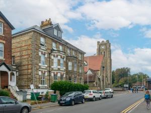 a street with cars parked in front of a building with a clock tower at Pass the Keys Spacious Sea Side apartment in Folkestone