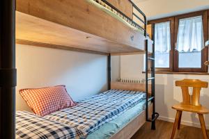 a bunk bed with a checkered pillow on the bottom bunk at Casa Caterina in Vigo di Fassa