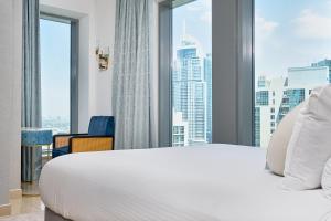 1 dormitorio con 1 cama blanca grande y ventana grande en Bellavista - Relaxing - 1 BR - 29 Boulevard - Partial Burj Khalifa & Fountain View, en Dubái