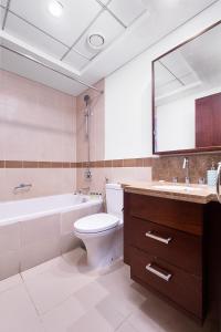 La salle de bains est pourvue de toilettes, d'une baignoire et d'un lavabo. dans l'établissement Bellavista - Relaxing - 1 BR - 29 Boulevard - Partial Burj Khalifa & Fountain View, à Dubaï