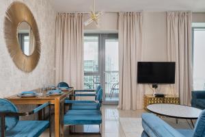 sala de estar con mesa, sillas y TV en Bellavista - Relaxing - 1 BR - 29 Boulevard - Partial Burj Khalifa & Fountain View, en Dubái